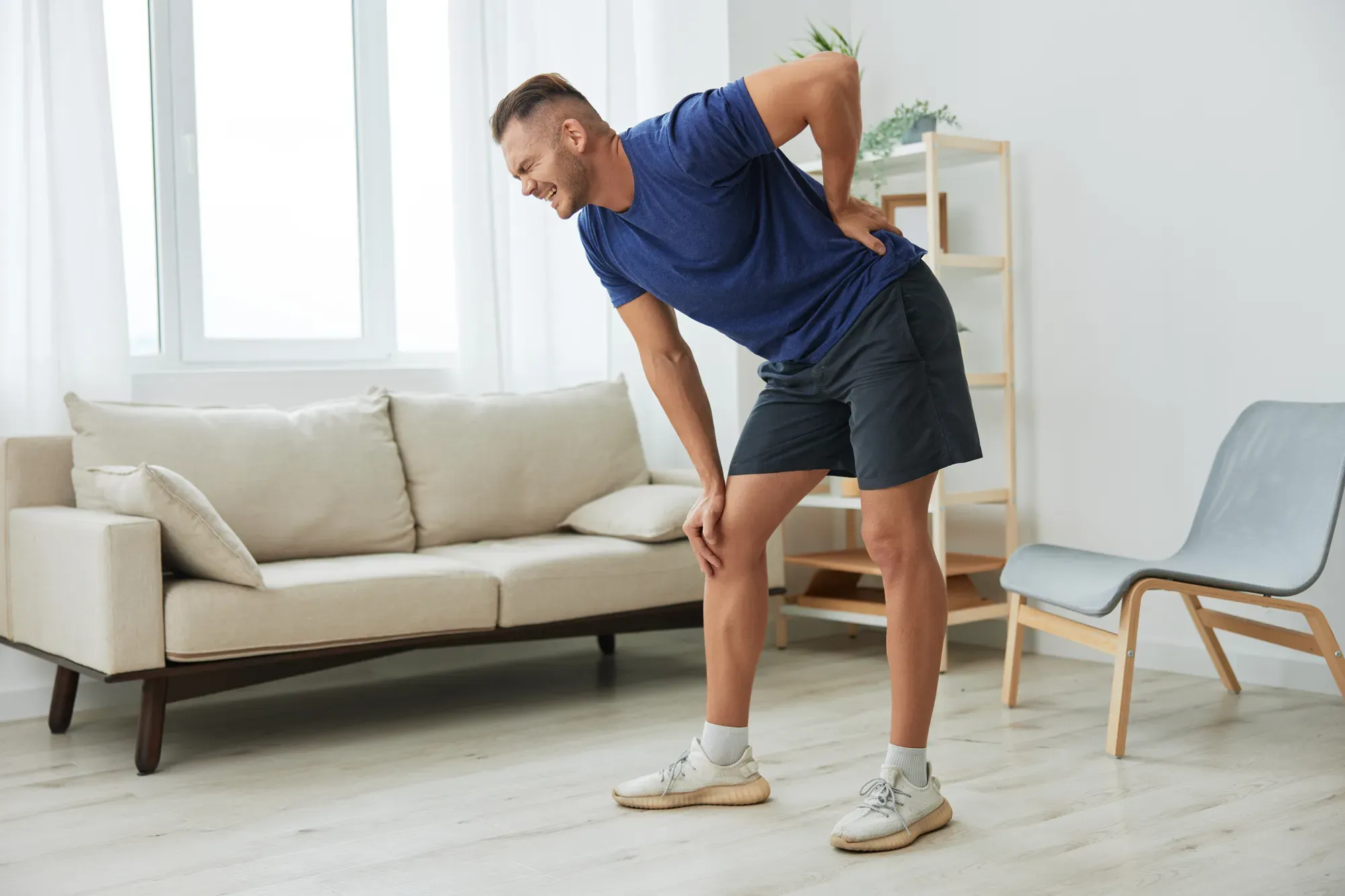 A man experiencing discomfort while bending.