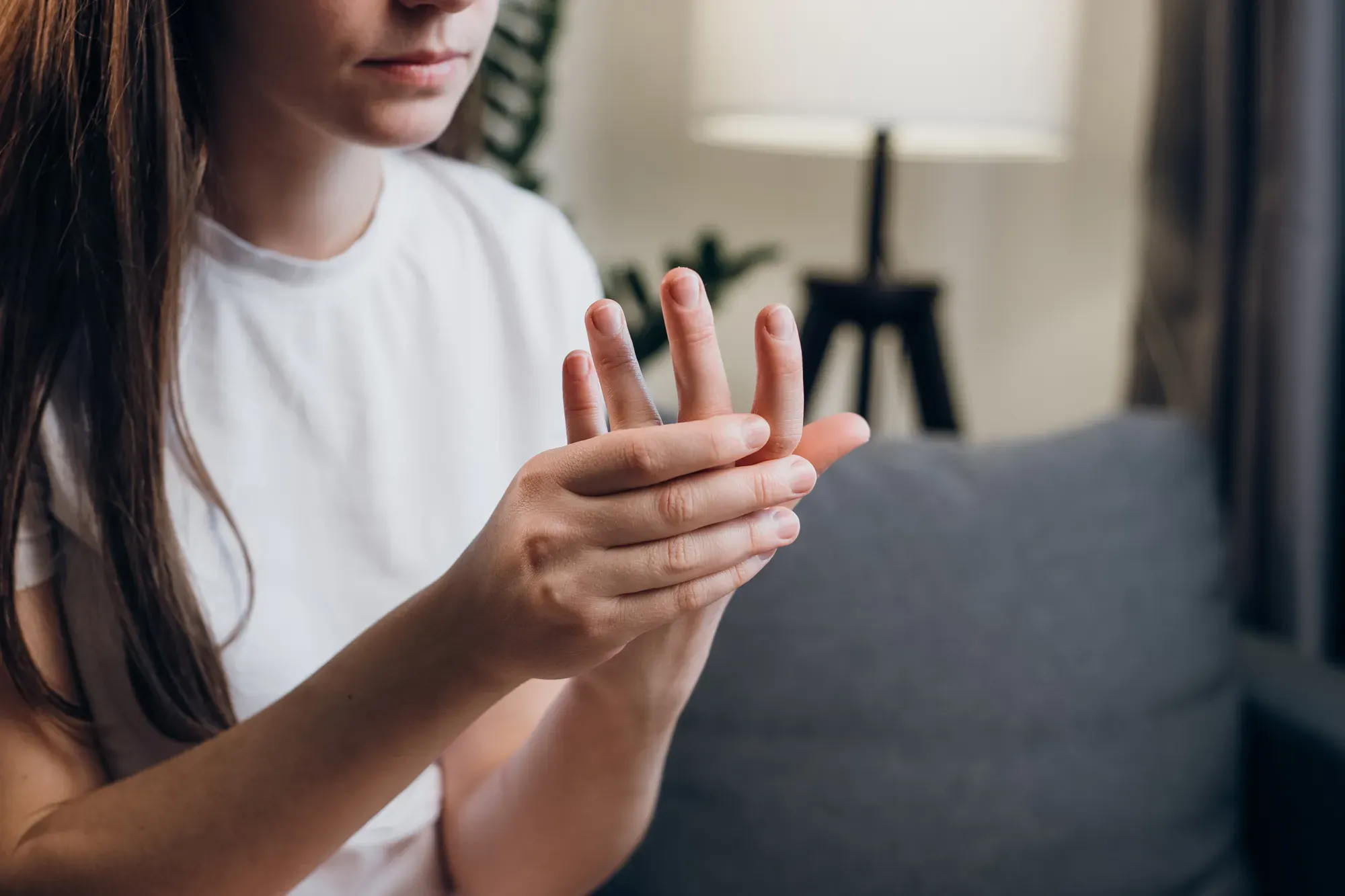 A woman experiencing numbness in her hands as a sign of nerve compression