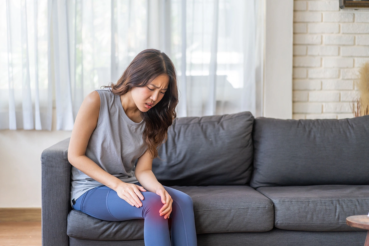 A woman suffering from severe knee pain