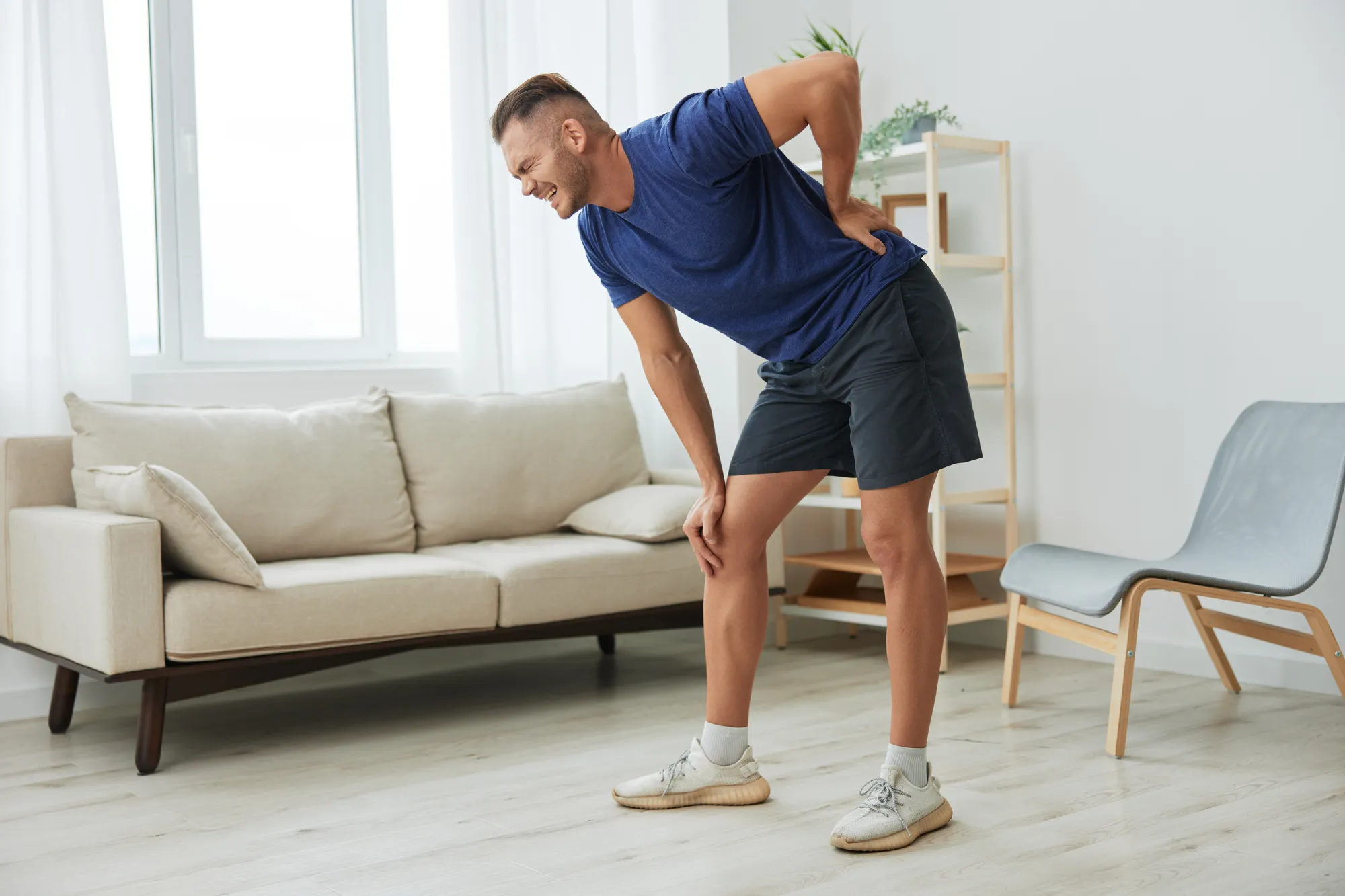 A man experiencing discomfort while bending.