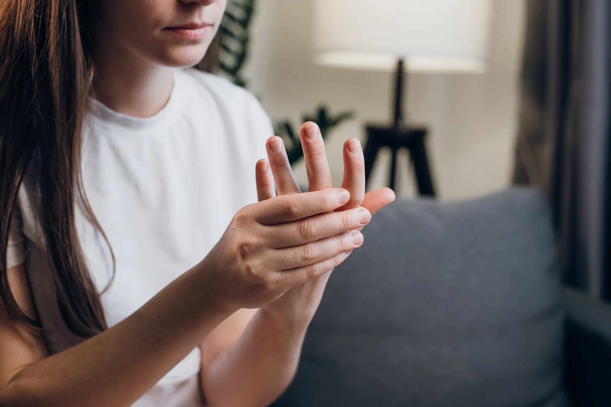A woman experiencing numbness in her hands as a sign of nerve compression